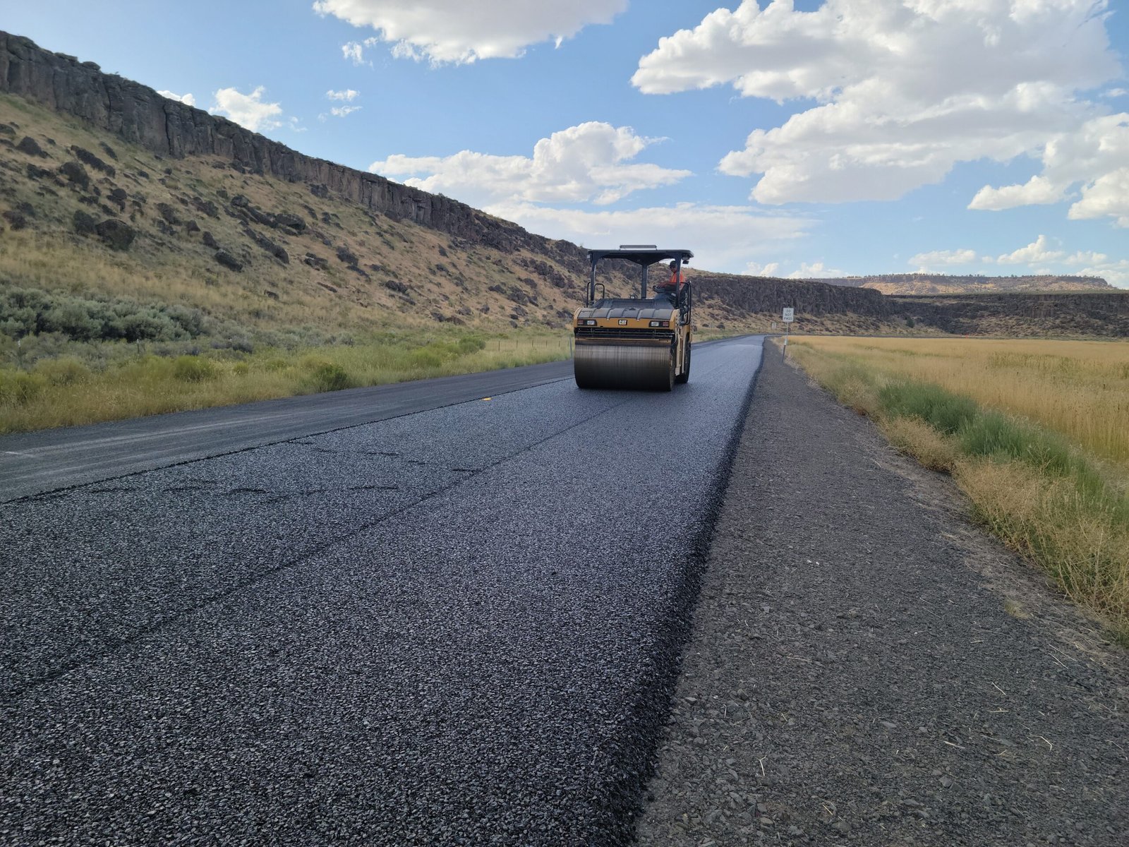 Road roller compacting a newly laid asphalt road