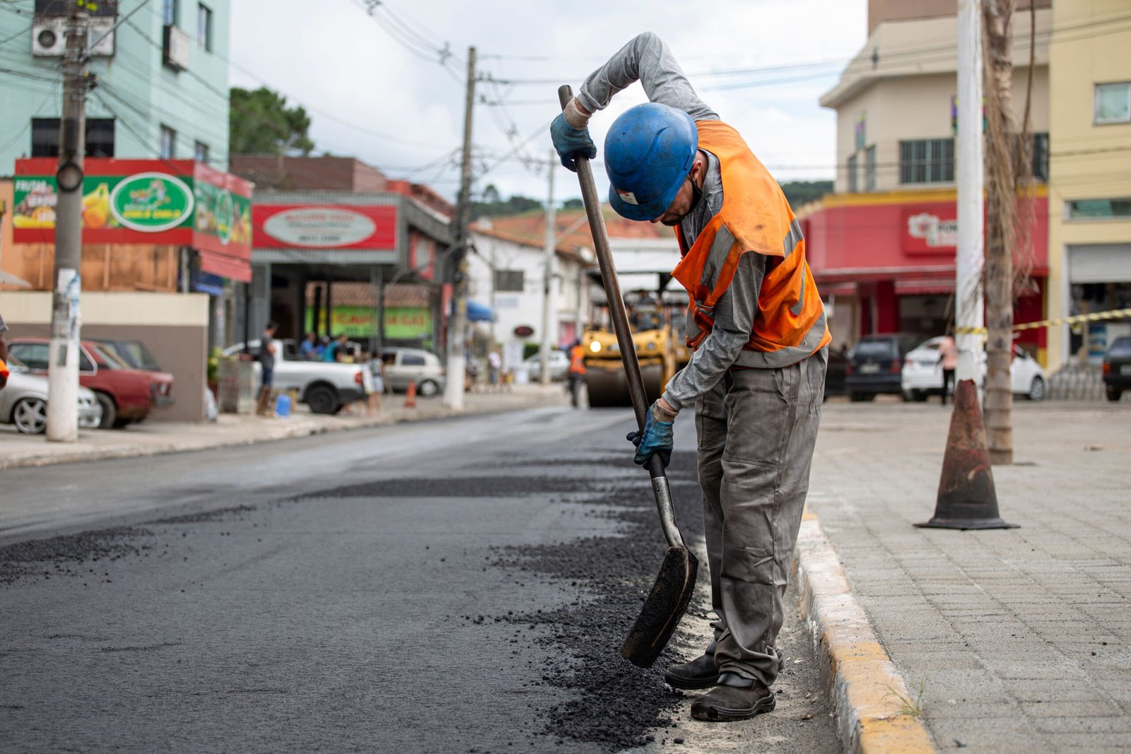 Road worker applying asphalt during paving